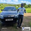 Customer standing beside a dark TOYOTA HARRIER supplied through EVERYCAR.jp