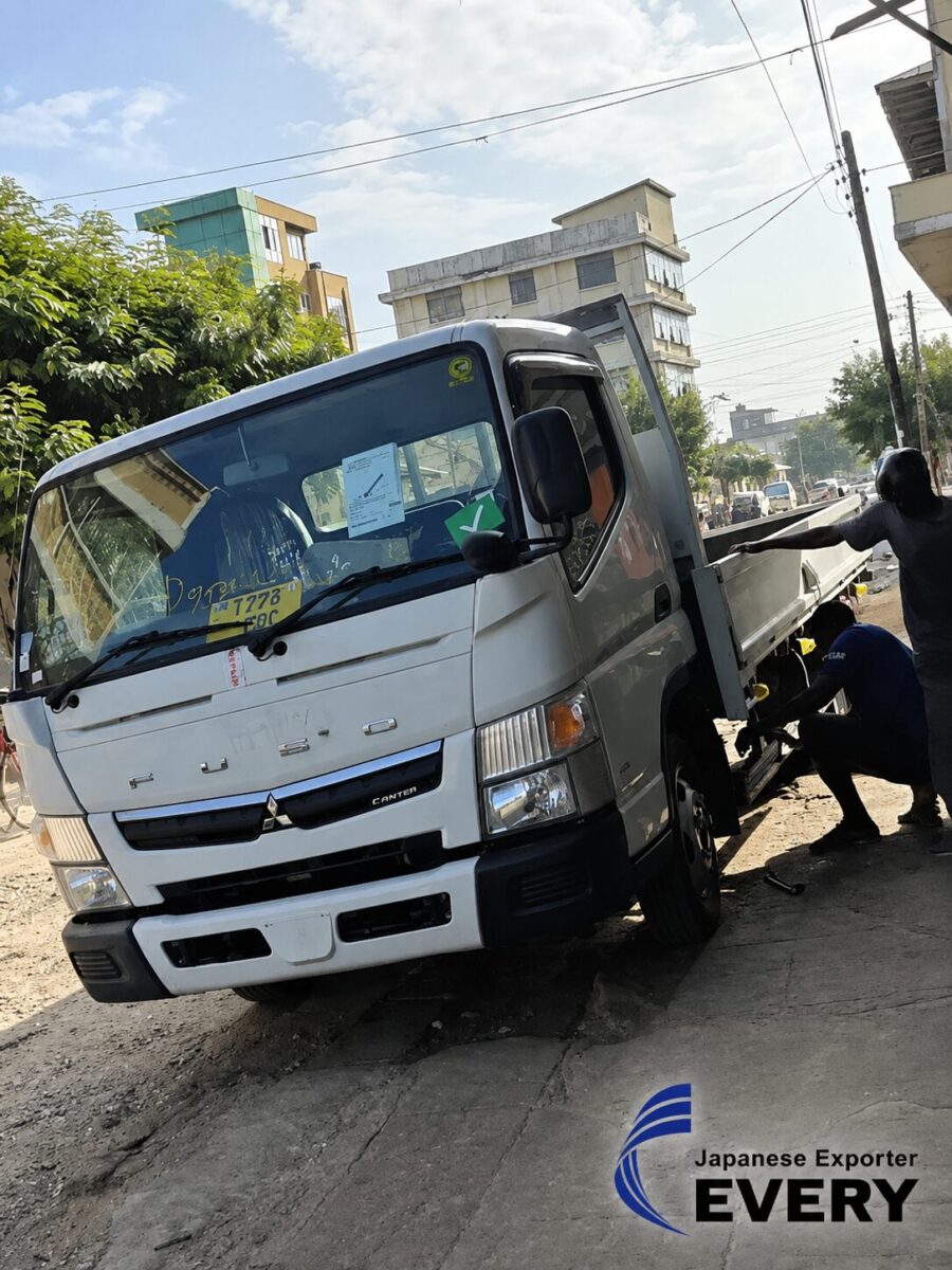 Customer in Tanzania with a white MITSUBISHI CANTER supplied through EVERYCAR.jp