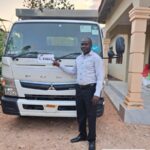 Customer with a MITSUBISHI CANTER flatbed truck exported from Japan to Zambia through EVERYCAR.jp
