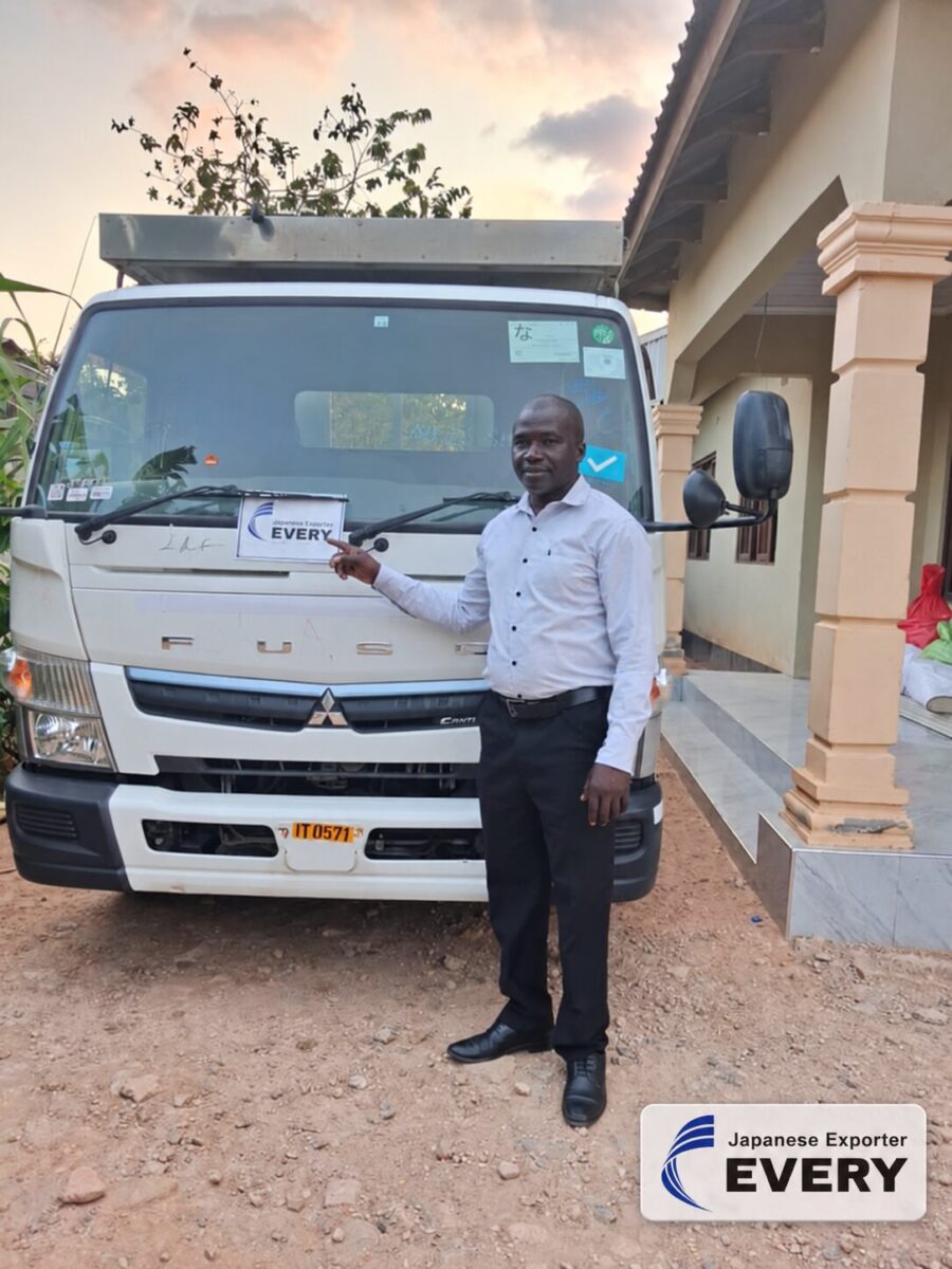 Customer with a MITSUBISHI CANTER flatbed truck exported from Japan to Zambia through EVERYCAR.jp